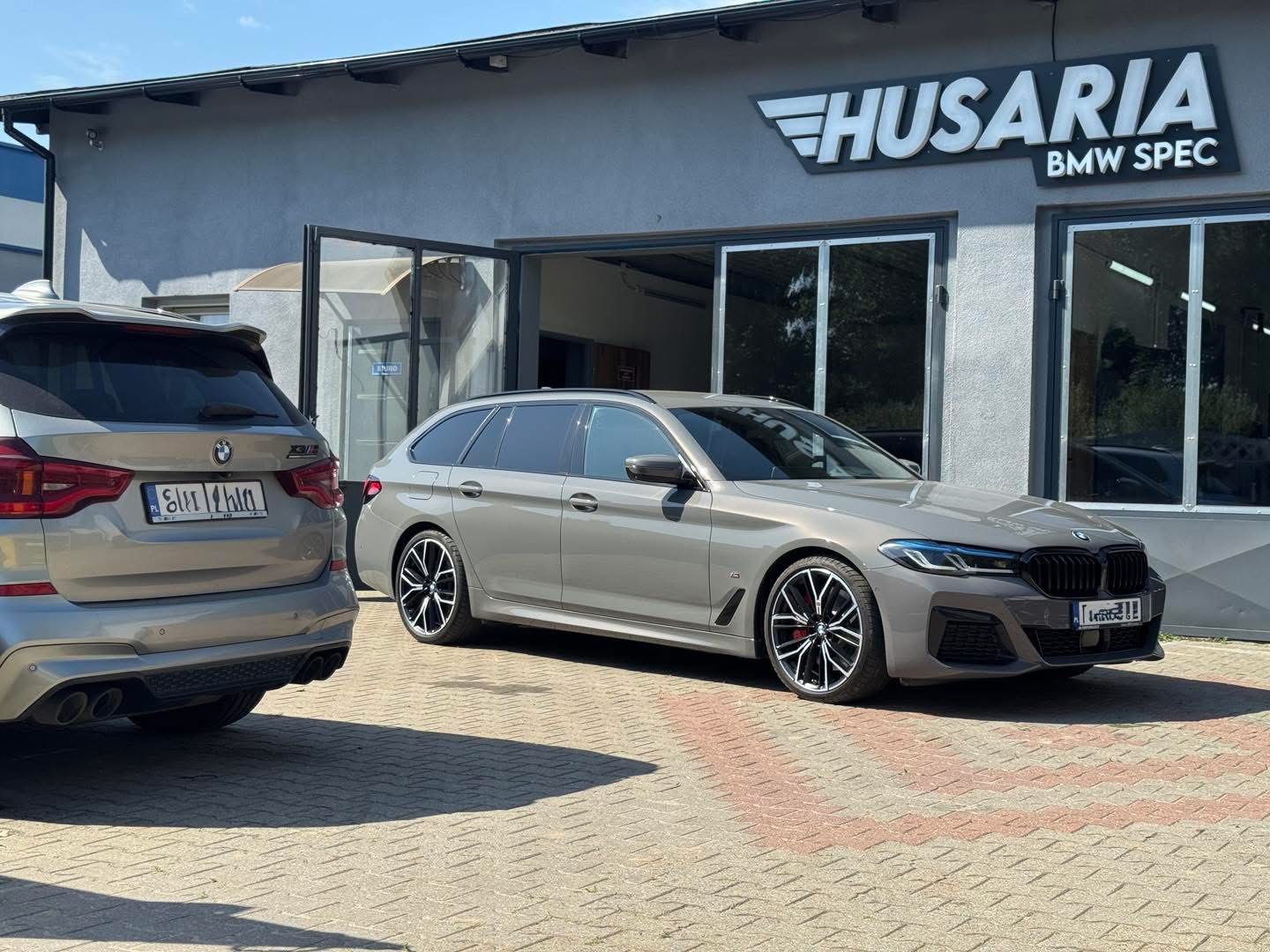 Dwa nowoczesne BMW przed warsztatem Husaria BMW Spec.
